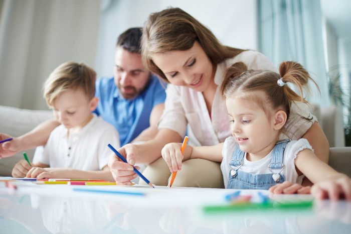 Mother helping her little daughter to draw