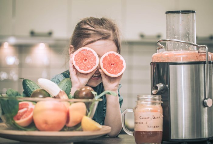 little cute happy girl preparing juice fresh in the kitchen, concept of healthy baby food and happy family
